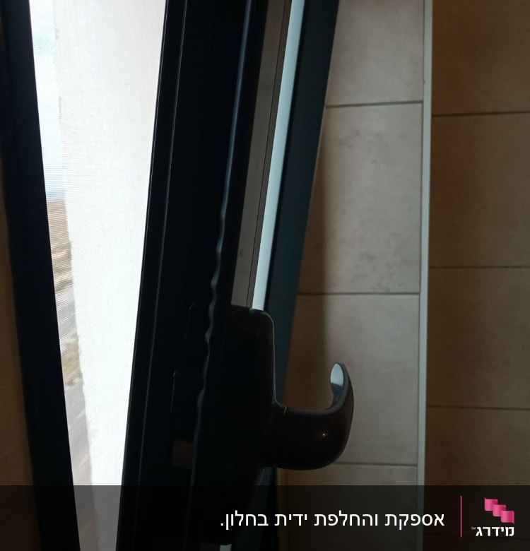 ידית תריס שחורה על חלון פתוח